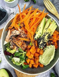 Buddha bowl med kål, bagte søde kartofler, laks og avocadodip