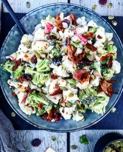 Cremet blomkålssalat med broccoli, æbler, tranebær og bacon