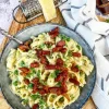 Cremet pastaret med squash, ærter og bacon