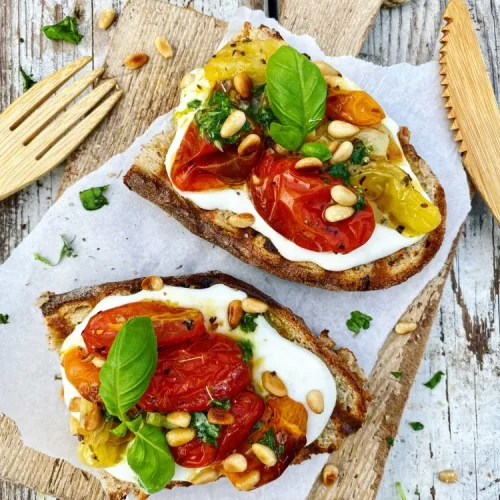 Ristet brød med fetacreme, bagte tomater, basilikumolie og ristede pinjekerner