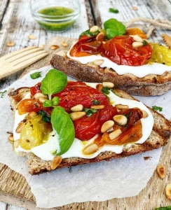 Ristet brød med fetacreme, bagte tomater, basilikumolie og ristede pinjekerner