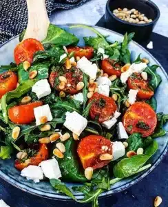 Rucolasalat med bagte tomater, feta og pinjekerner